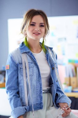 Moda tasarımcısı kadın stüdyoda tasarımları üzerinde çalışıyor.