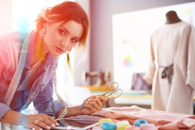 Moda tasarımcısı kadın stüdyoda tasarımları üzerinde çalışıyor..