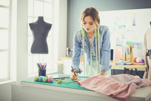 Mulher designer de moda trabalhando em seus projetos no estúdio — Fotografia de Stock