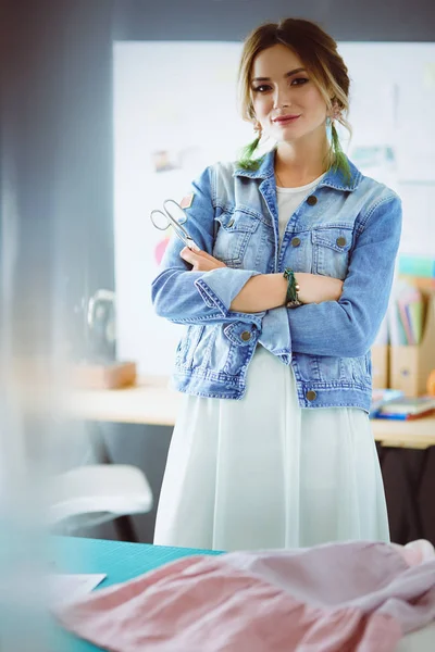 Moda tasarımcısı kadın stüdyoda tasarımları üzerinde çalışıyor.