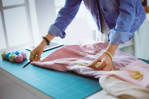 Moda tasarımcısı kadın stüdyoda tasarımları üzerinde çalışıyor.