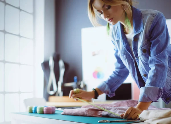 Mulher designer de moda trabalhando em seus projetos no estúdio — Fotografia de Stock