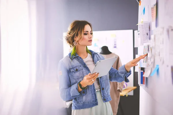 Donna stilista che lavora sui suoi disegni in studio — Foto Stock