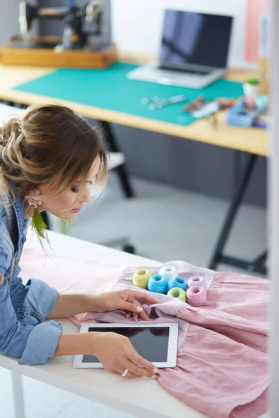 Moda tasarımcısı kadın stüdyoda tasarımları üzerinde çalışıyor.