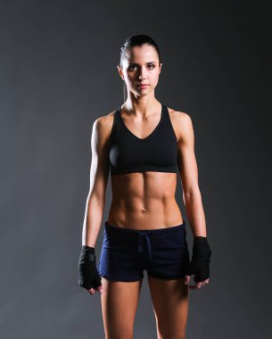 Spor giyim siyah arka plan karşı poz kas genç kadın