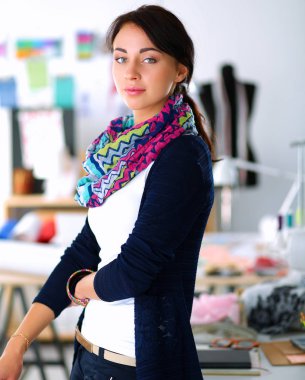 Güzel moda tasarımcısı stüdyoda duruyor.