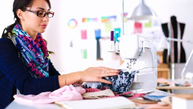 Çalışırken dikiş diken genç bir kadın.