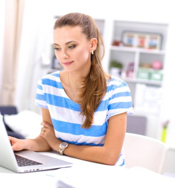 Elinde evrakları olan kadın masanın üstünde oturuyor.