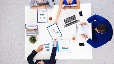 İş adamları iş toplantısında, ofiste oturup tartışıyorlar.