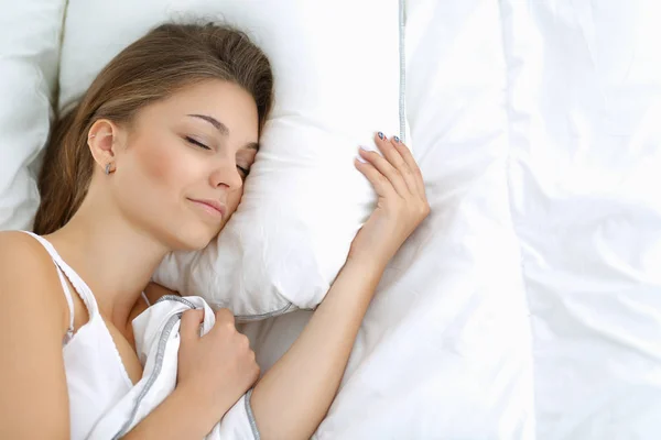 Μια όμορφη νεαρή γυναίκα ξαπλωμένη στο κρεβάτι άνετα και χαρούμενα — Φωτογραφία Αρχείου