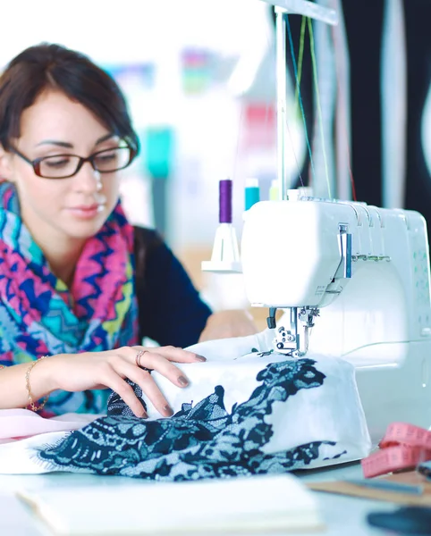 Çalışırken dikiş diken genç bir kadın.