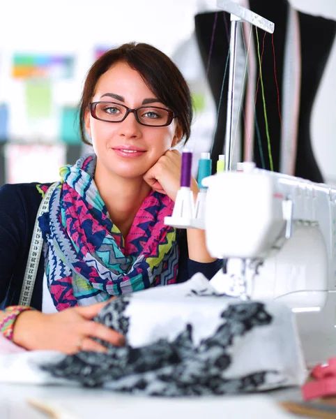 Çalışırken dikiş diken genç bir kadın.