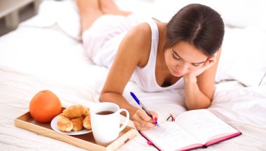 Bir günlük yazma yatakta yatan genç güzel kadın