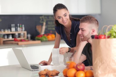 Çift evde mutfak içinde laptop ile onların fatura ödeme