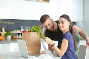 Çift evde mutfak içinde laptop ile onların fatura ödeme