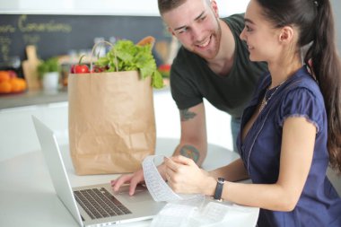 Çift evde mutfak içinde laptop ile onların fatura ödeme