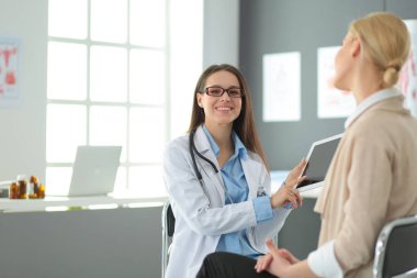 Doktor ve hasta masada otururken bir şey tartışıyorlar. İlaç ve sağlık hizmetleri kavramı