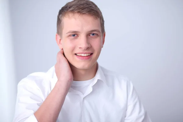 Porträtt av ung man leende sitter på grå bakgrund. Porträtt av ung man — Stockfoto