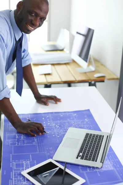 Arquitecto afroamericano trabajando con computadoras y planos en la oficina — Foto de Stock