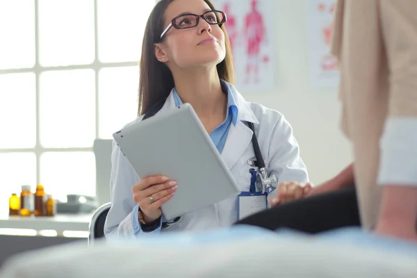 Dottore e paziente discutono di qualcosa mentre sono seduti al tavolo. Medicina e concetto di assistenza sanitaria — Foto Stock