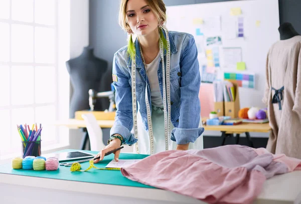 Donna stilista che lavora sui suoi disegni in studio — Foto Stock