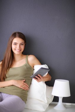 bir yastık ve uçak tablo ile katta oturan güzel esmer kadın