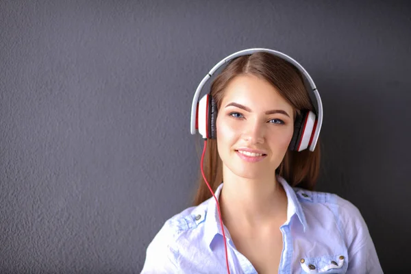 Gelukkig meisje zittend op de vloer en muziek luisteren — Stockfoto