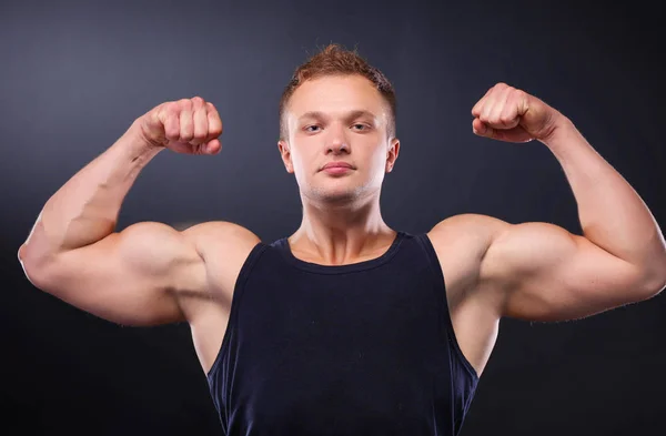 Starker und gut aussehender junger Bodybuilder demonstriert seine Muskeln und seinen Bizeps — Stockfoto