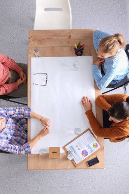 İş adamları toplantıda, ofiste oturup tartışıyorlar.