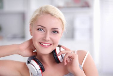 Evdeki genç ve güzel kadın kanepede oturup müzik dinliyor.