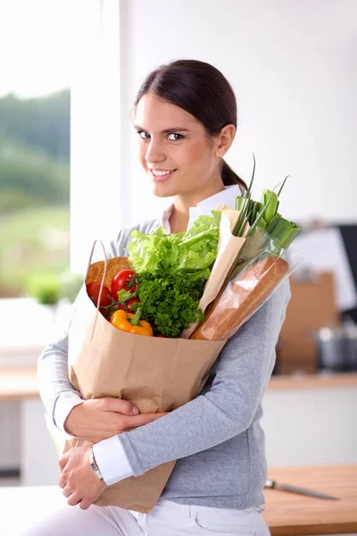 拿着蔬菜购物袋的年轻女子。站在厨房里 — 图库照片