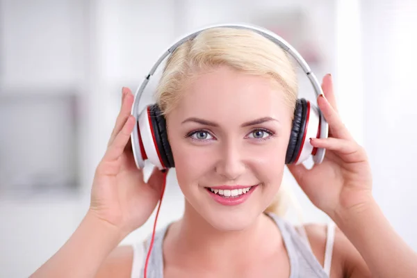 Joven hermosa mujer en casa sentada en el sofá y escuchando música —  Fotos de Stock