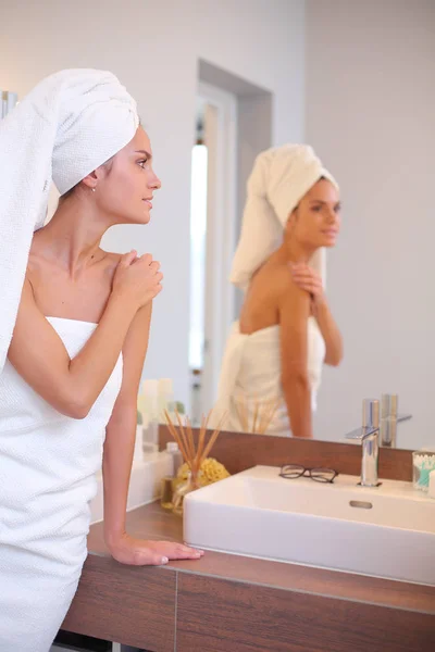 Jeune femme attrayante debout devant le miroir de salle de bain — Photo