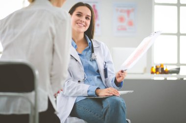 Doktor ve hasta masada otururken bir şey tartışıyorlar. İlaç ve sağlık hizmetleri kavramı