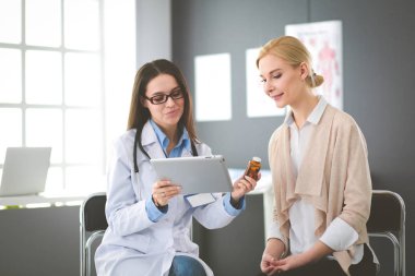 Doktor ve hasta masada otururken bir şey tartışıyorlar. İlaç ve sağlık hizmetleri kavramı