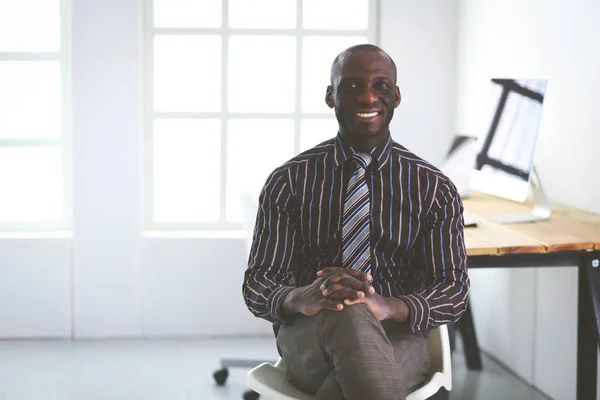 Retrato de um belo homem de negócios negro sentado no escritório — Fotografia de Stock