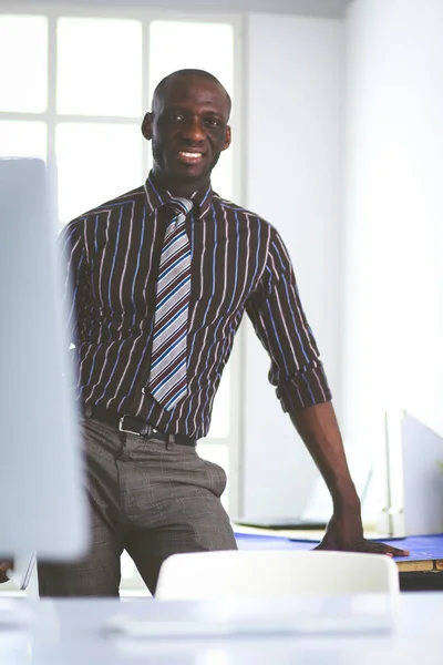 Arquiteto afro-americano trabalhando com computador e plantas no escritório — Fotografia de Stock