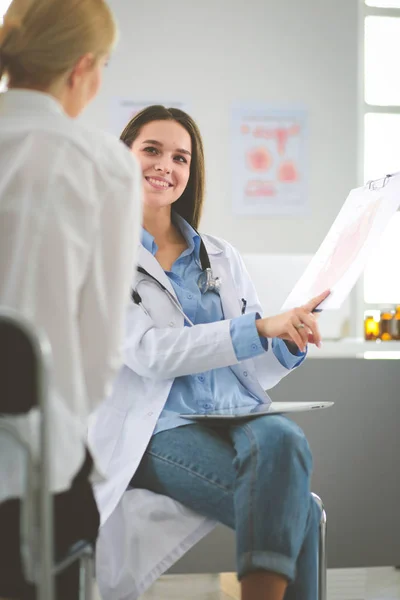 Doktorn och patienten diskuterar något när de sitter vid bordet. Medicin och hälsovård — Stockfoto