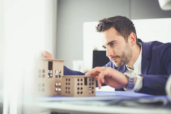 Businessman holding house miniature on hand standing in office. — Stock Photo, Image