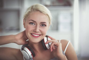 Evdeki genç ve güzel kadın kanepede oturup müzik dinliyor.