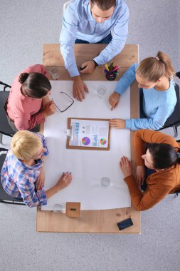 İş adamları toplantıda, ofiste oturup tartışıyorlar.