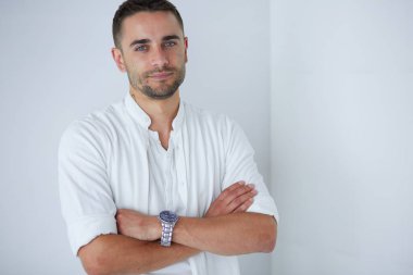 Genç iş adamı beyaz arka planda tek başına duruyor.