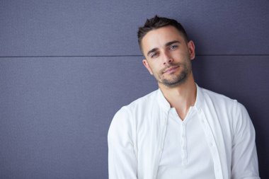 Gri arka planda yalnız oturan genç iş adamı