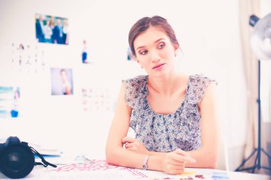 Çatı katı dairesinde oturan kamera ile gülümseyen genç kadın portresi