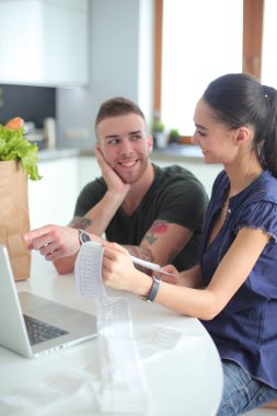 Çift evde mutfak içinde laptop ile onların fatura ödeme