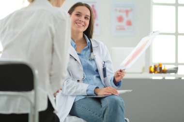 Doktor ve hasta masada otururken bir şey tartışıyorlar. İlaç ve sağlık hizmetleri kavramı