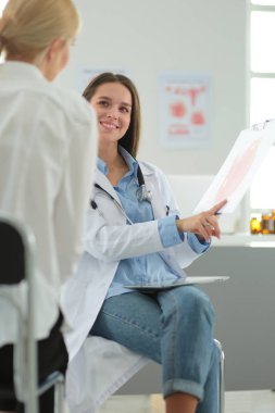 Doktor ve hasta masada otururken bir şey tartışıyorlar. İlaç ve sağlık hizmetleri kavramı