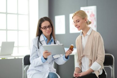 Doktor ve hasta masada otururken bir şey tartışıyorlar. İlaç ve sağlık hizmetleri kavramı