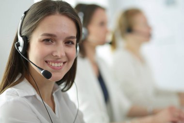 Ofisinde kulaklık ve bilgisayarla gülümseyen iş kadını ya da yardım hattı operatörü