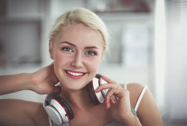 Joven hermosa mujer en casa sentada en el sofá y escuchando música —  Fotos de Stock